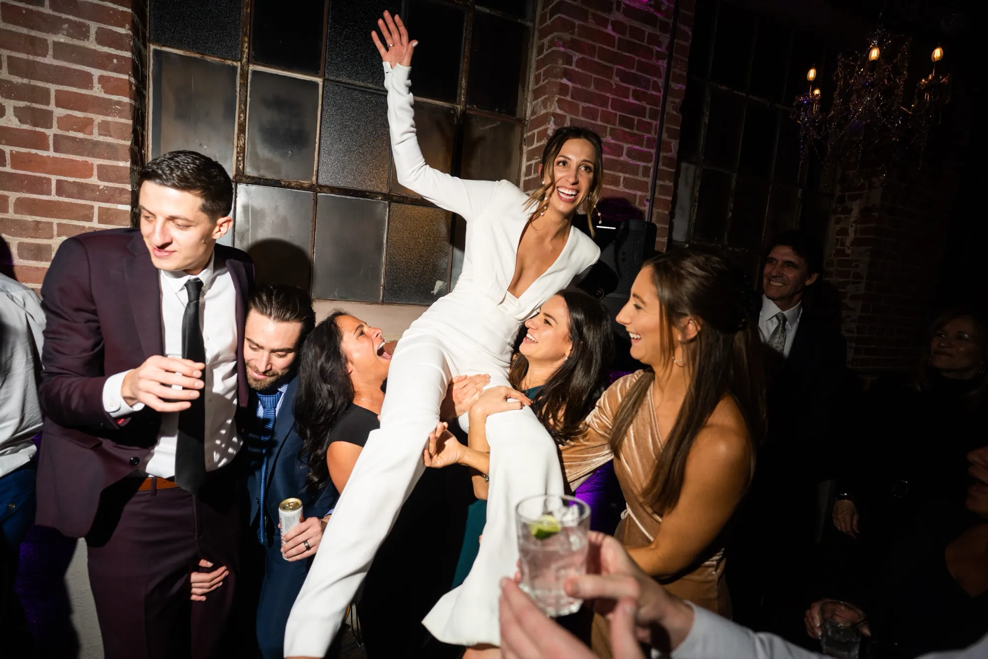 The bride and groom celebrating with friends on the dance floor at the DelPiccolo wedding at Moss Denver