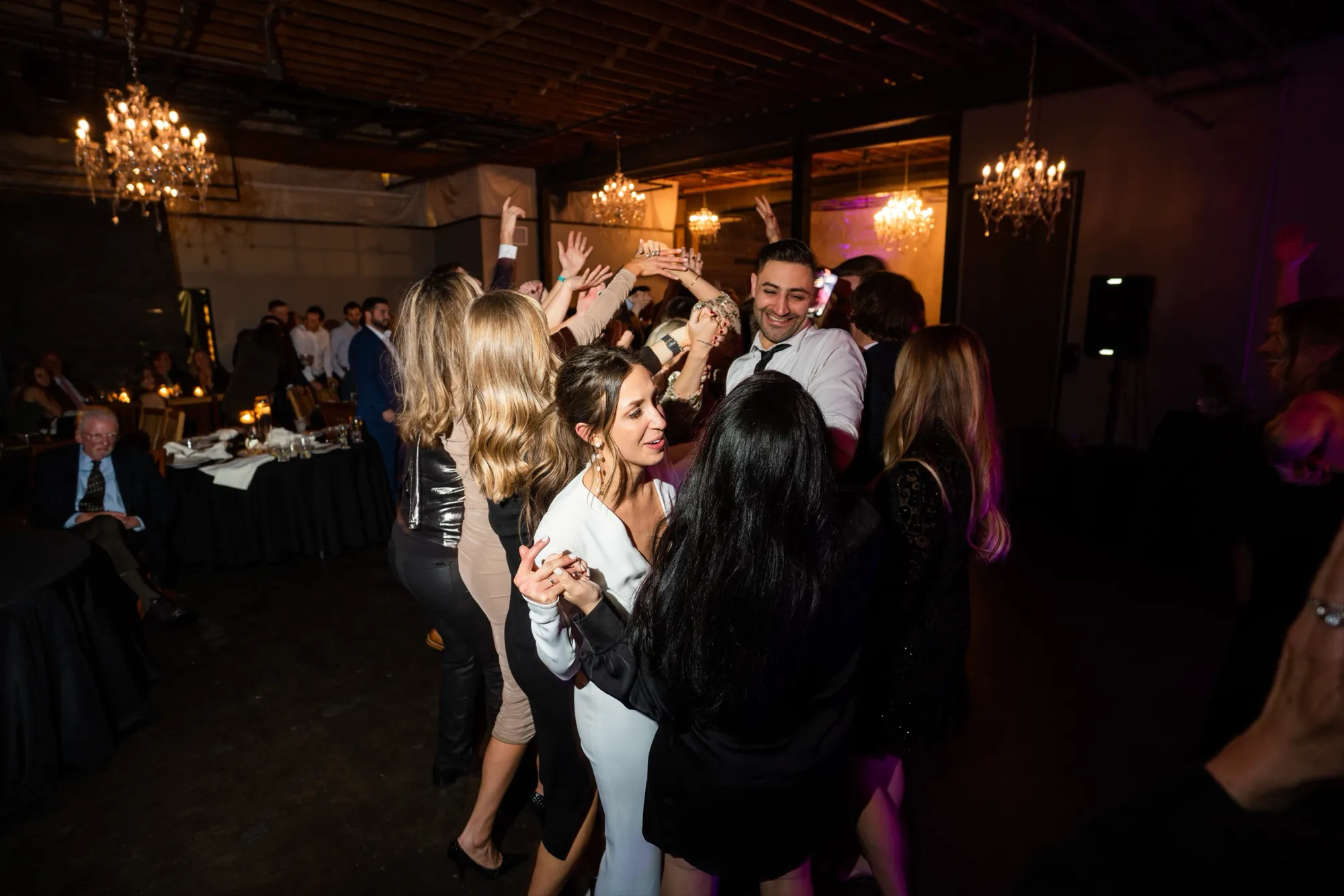 Guests with their hands in the air on a packed dance floor at the DelPiccolo wedding at Moss Denver