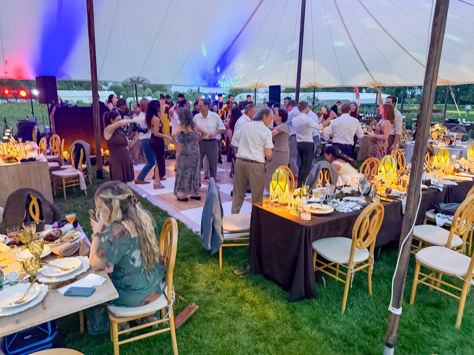 Candlelit dinner tables inside the reception tent at Boulder Flower Farm
